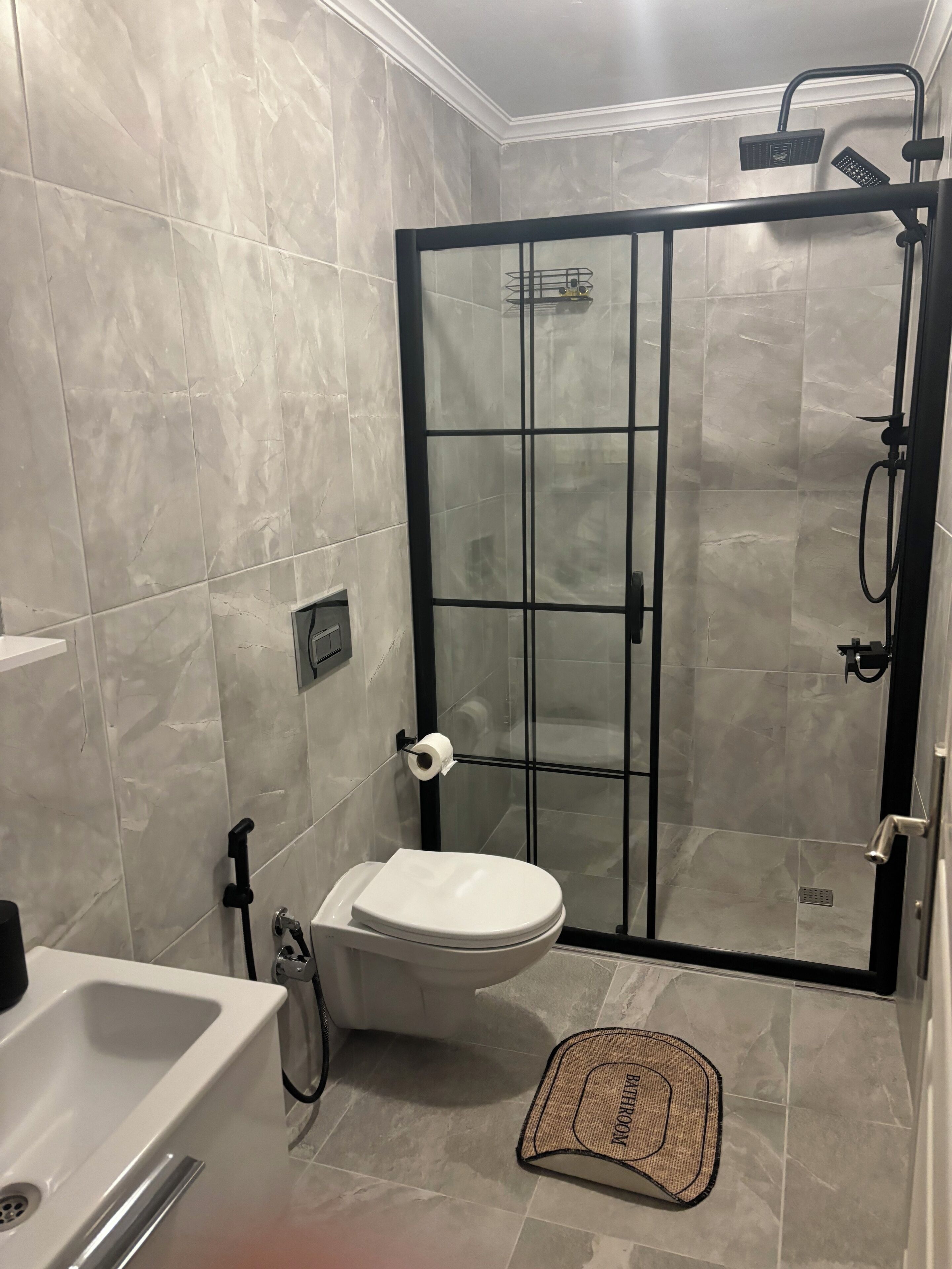 A modern bathroom with a glass-enclosed shower, a toilet, and a bathtub.