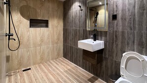 Une salle de bain moderne équipée d’une douche, d’un lavabo et de toilettes.