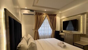 Une chambre d’hôtel moderne dotée d’un grand lit, d’une télévision à écran plat, d’un minibar et de la climatisation.