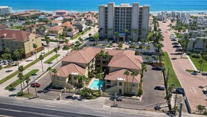 A coastal hotel with multiple buildings, a parking lot, and a view of the ocean. - Pool - Beach Access - Near Claytons Private (South Padre Island)