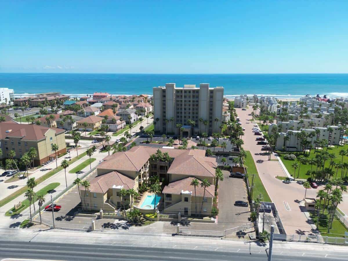 Un hotel frente al mar con varias construcciones, una piscina y vistas al océano.