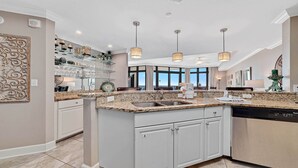 A spacious kitchen with granite countertops, white cabinetry, and pendant lighting. - 3rd Floor!! Parking Level!  Avoid the Elevators!! (Orange Beach)