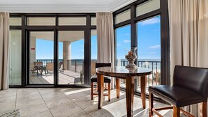 A spacious balcony with a view of the beach, a round table with chairs, and a decorative vase. - 3rd Floor!! Parking Level!  Avoid the Elevators!! (Orange Beach)
