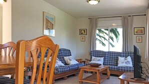 A living room with a sofa, chairs, a coffee table, and a television. - Villa with shared Pool/Aircon/Wi-Fi - Villa Mimosa (L'Escala)