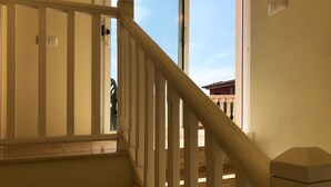 A staircase with white balusters and a handrail, leading to a room with a large window. - Villa with shared Pool/Aircon/Wi-Fi - Villa Mimosa (L'Escala)