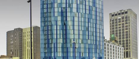 A tall, cylindrical building with a modern glass facade.