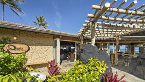 Ein Restaurant mit einer Steinfassade, Außenplätzen und Blick aufs Meer.