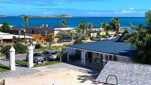Ein Küstenwohngebiet mit Häusern, blauem Himmel und Blick auf das Meer.