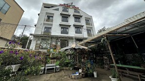 A multi-story building with a balcony and a sign above the entrance. - OYO 1204 Hoang Linh Hotel (Xuan Huong - Da Lat)