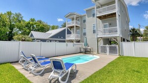 A two-story house with a backyard swimming pool, a fenced area, and a patio with lounge chairs. - Spacious 4 Bedroom, 3.5 Bath Garden City Beach Home with Private Pool (Garden City Beach)