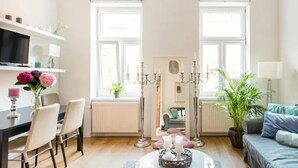 A bright living room with a dining area, large windows, and a sofa. - Luxurious and Bright, 5 min walk to city center (Vienna)