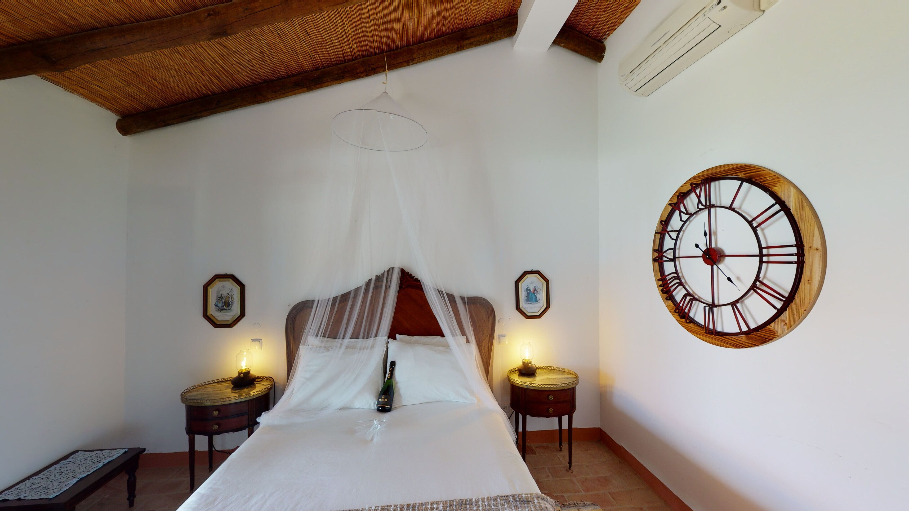 Une chambre à coucher avec un lit, un plafond en bois, une horloge murale et des lampes de chevet.