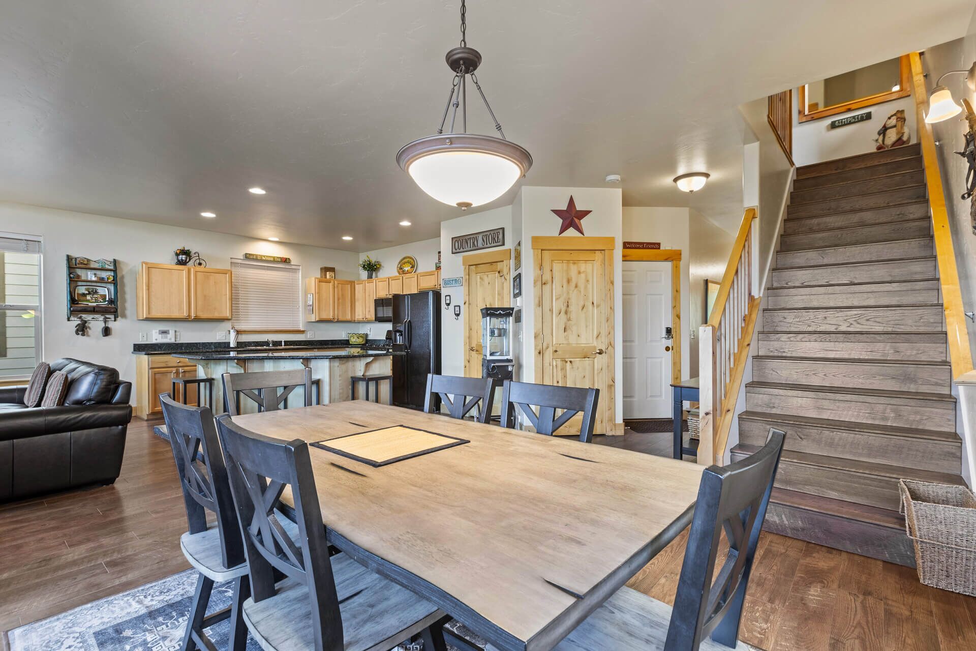 Una cocina amplia con armarios de madera, una mesa de comedor y una escalera que sube a otro nivel.