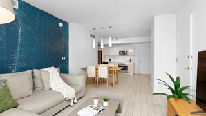 Un salon moderne comprenant un canapé, une table basse et un coin repas avec des chaises et une table.