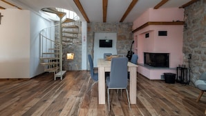 A rustic interior with a spiral staircase, a fireplace, and a dining area. - Villa Emanuel in Ljubitovica  - Haus für 4-6 Personen (Ljubitovica)