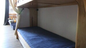 Un letto a castello con struttura in legno e materasso blu.