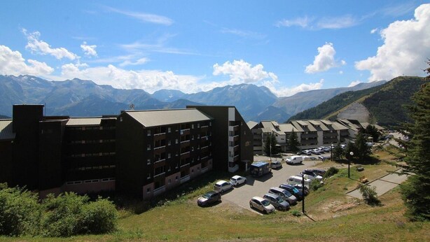 Un hotel a più piani con un parcheggio in zona montana.