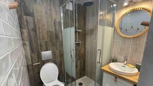 A modern bathroom with a glass-enclosed shower, a white toilet, and a sink with a wooden countertop. - 10m from resort center, 11st floor, view lake, tv, ski locker, 12m², Tignes (Tignes)