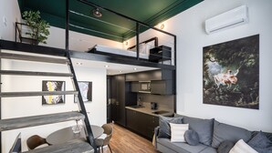A modern loft-style apartment with a dining area, kitchen, and living space. - E41 Boutique Apartments by BQA (Budapest)