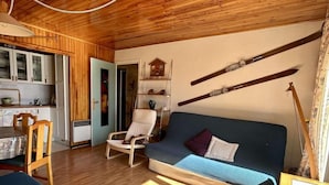 Une pièce confortable avec un canapé, un fauteuil et une table à manger.