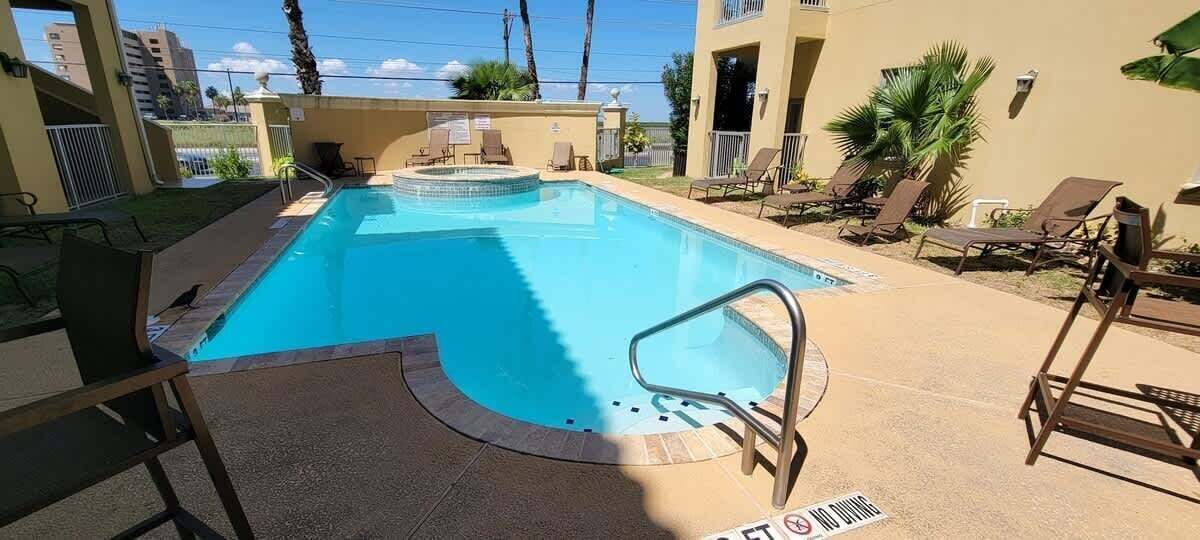 Une piscine dotée de chaises longues et d’un espace aménagé au bord de la piscine.