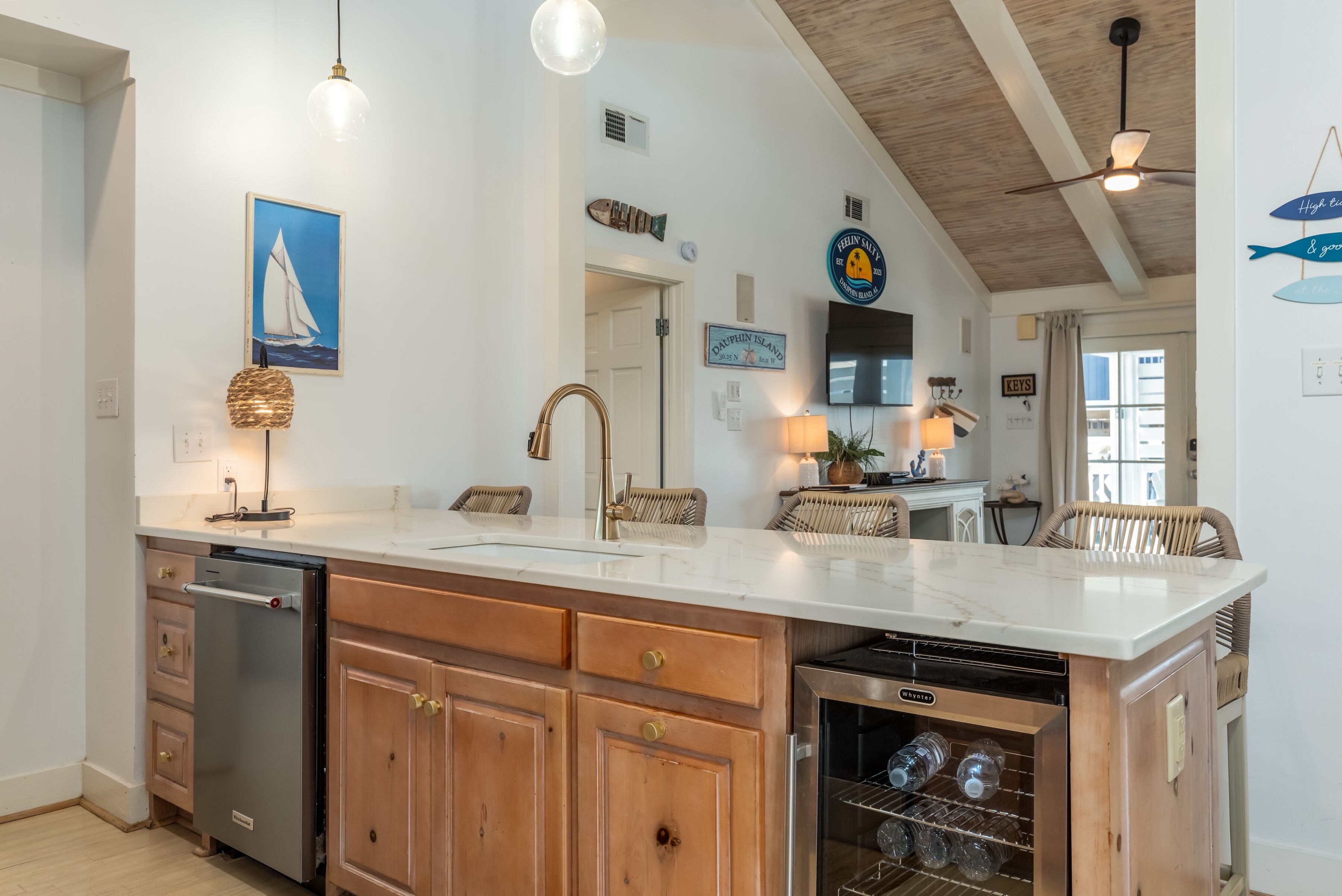 A kitchen with a large island, wooden cabinets, and a built-in dishwasher.