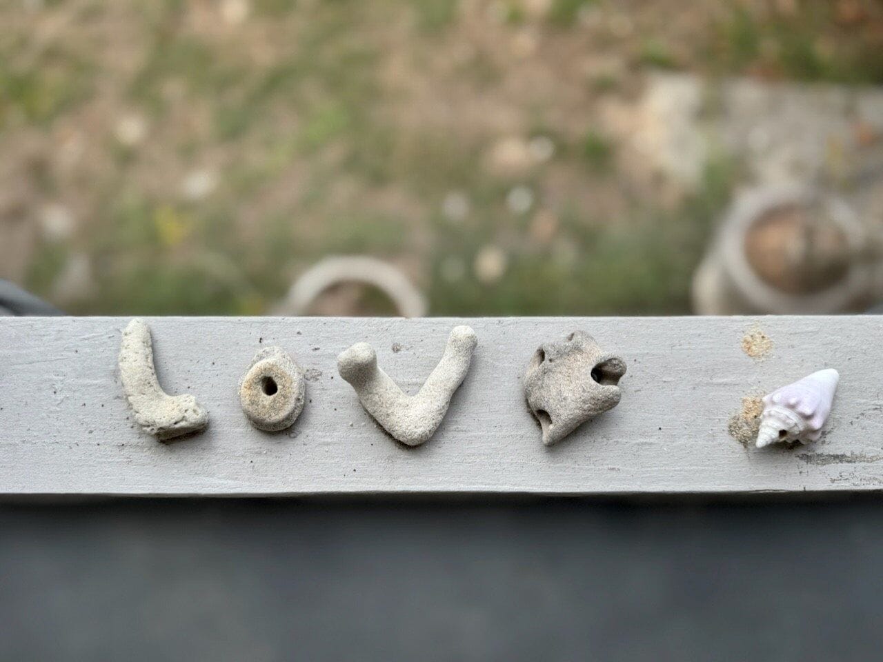 A wooden surface with the word "LOVE" spelled out in rough, natural textures.