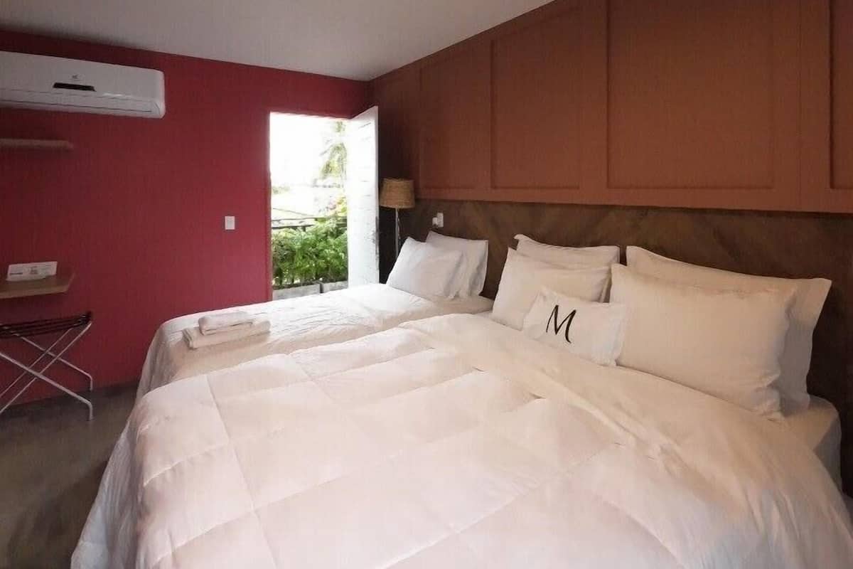 Un dormitorio con una cama grande, una lámpara en el techo y una pared roja.