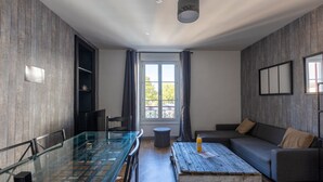 A modern living room with a glass dining table, a sofa, and a coffee table. - Résidence Kméléon (Le Mans)