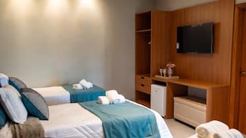 A hotel room with two beds, a TV, a small desk, and a wardrobe.