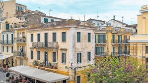 A courtyard with outdoor seating, a bike rack, and a building with balconies. - Isidora's House by Corfuescapes (Corfu)