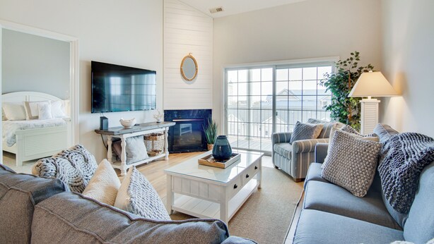 A modern living room with a fireplace, a television, and a large window. - Walk to Boardwalk! Ocean City Coastal Gem w/ Deck (Ocean City)