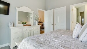 A bedroom with a large bed, a dresser with a mirror, and two doors leading to other rooms. - Walk to Boardwalk! Ocean City Coastal Gem w/ Deck (Ocean City)