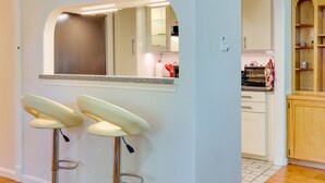 A kitchen with white cabinets, a wooden cabinet, and a countertop with a kettle. - Pet-friendly Houston Vacation Rental w/ Patio! (Houston)