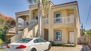 A two-story building with a white car parked in front. - South Padre Island Condo w/ Shared Outdoor Pool! (South Padre Island)