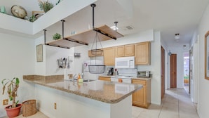 A modern kitchen with granite countertops, wooden cabinets, and a central island. - 6 Mi to Disney: Family-friendly Condo in Kissimmee (Kissimmee)