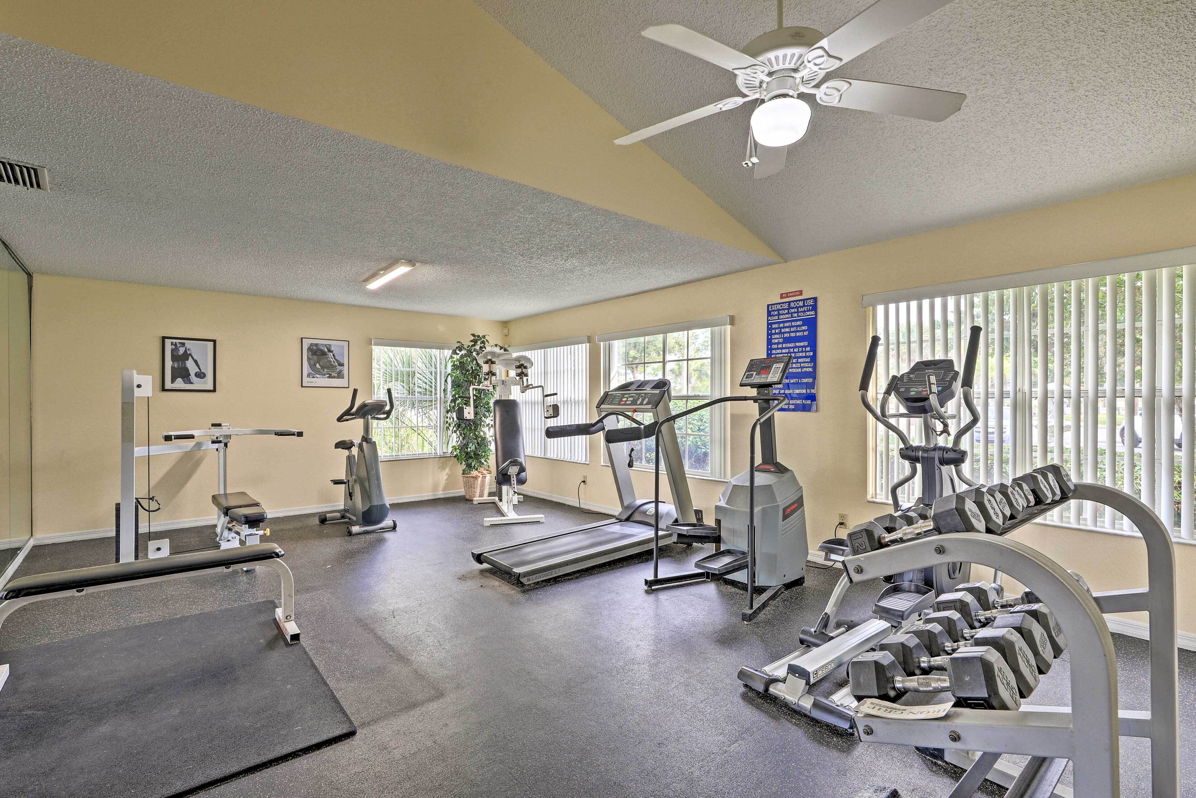 A gym with treadmills, weight machines, and dumbbells.