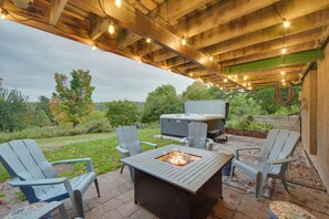 An outdoor patio with Adirondack chairs, a fire pit, and a hot tub. - Hermantown Home w/ Decks, Grill & Hot Tub! (Duluth)