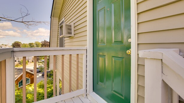 A green door with a white frame, a small porch with a white railing, and a view of a residential street. - Old Orchard Beach Vacation Rental, Walk to Ocean! (Old Orchard Beach)