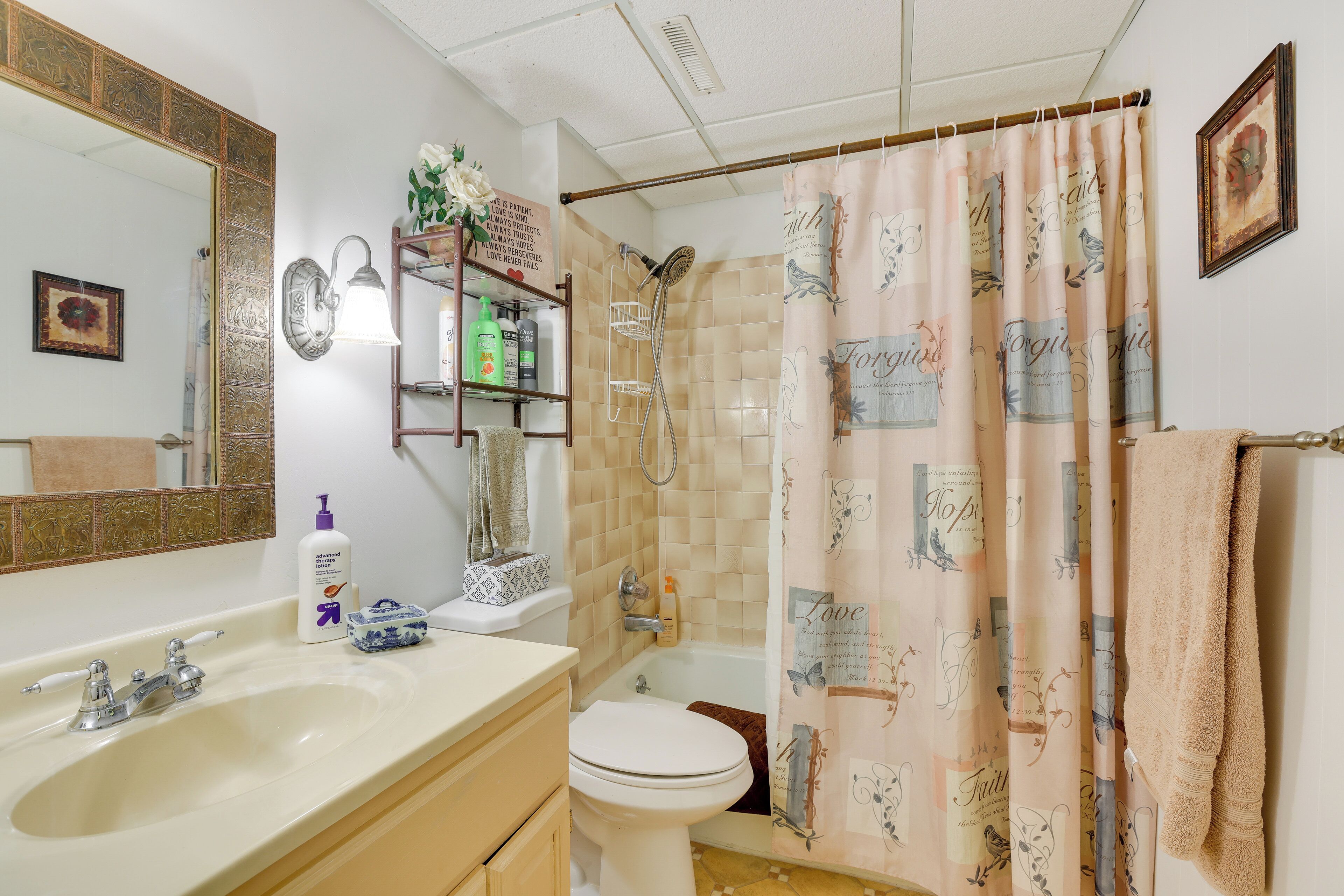 Een badkamer met een wastafel, toilet, douche en spiegel.