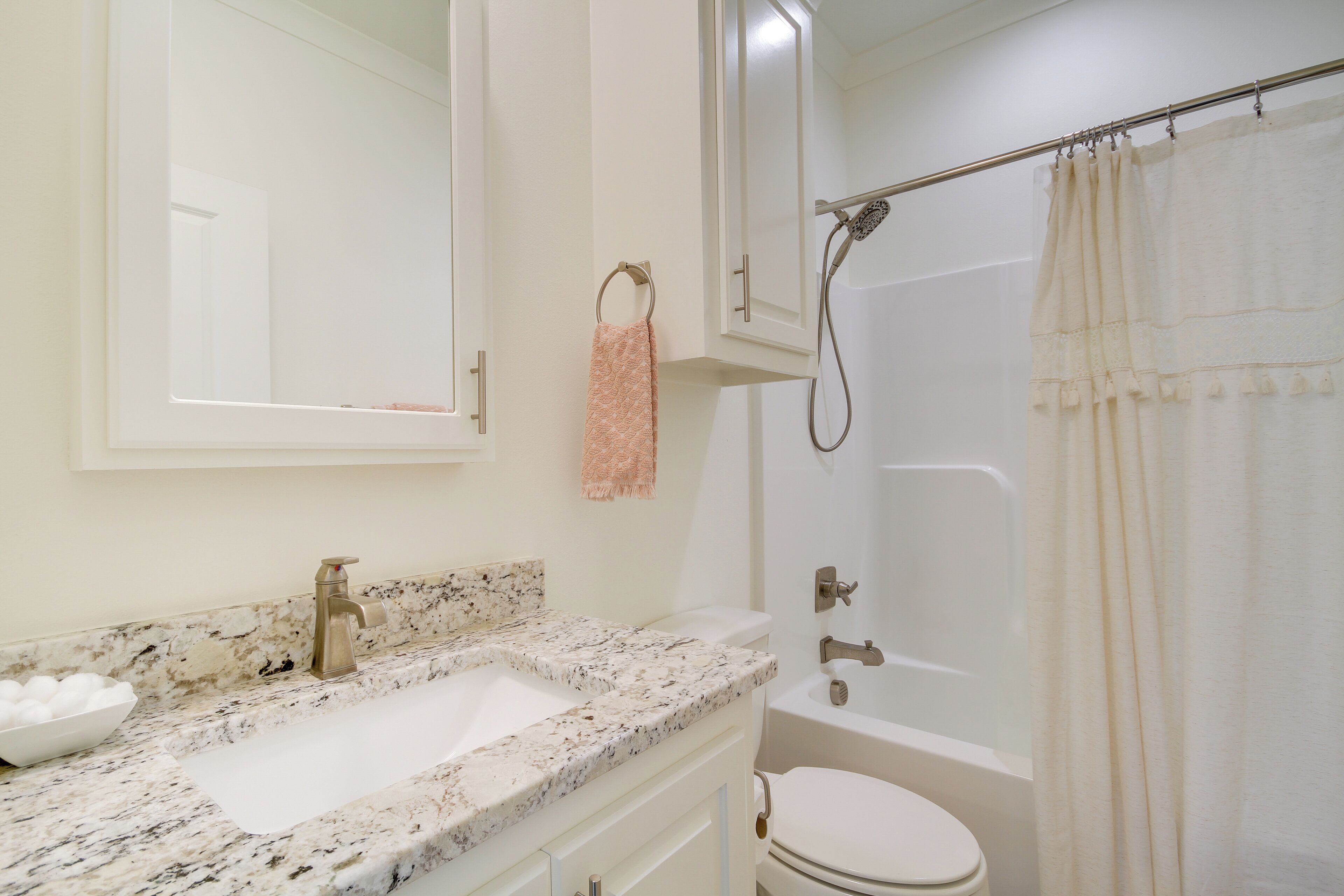 Une salle de bain avec un lavabo en marbre, des toilettes, une douche et un miroir.