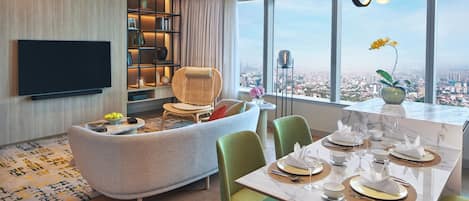 Una sala moderna con sofá, comedor y televisor.