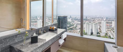 A modern bathroom with a large window, a marble sink, and a city view.