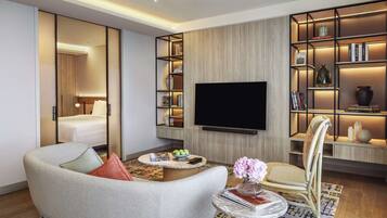 A modern living room with a sofa, a coffee table, a TV, and a bookshelf.
