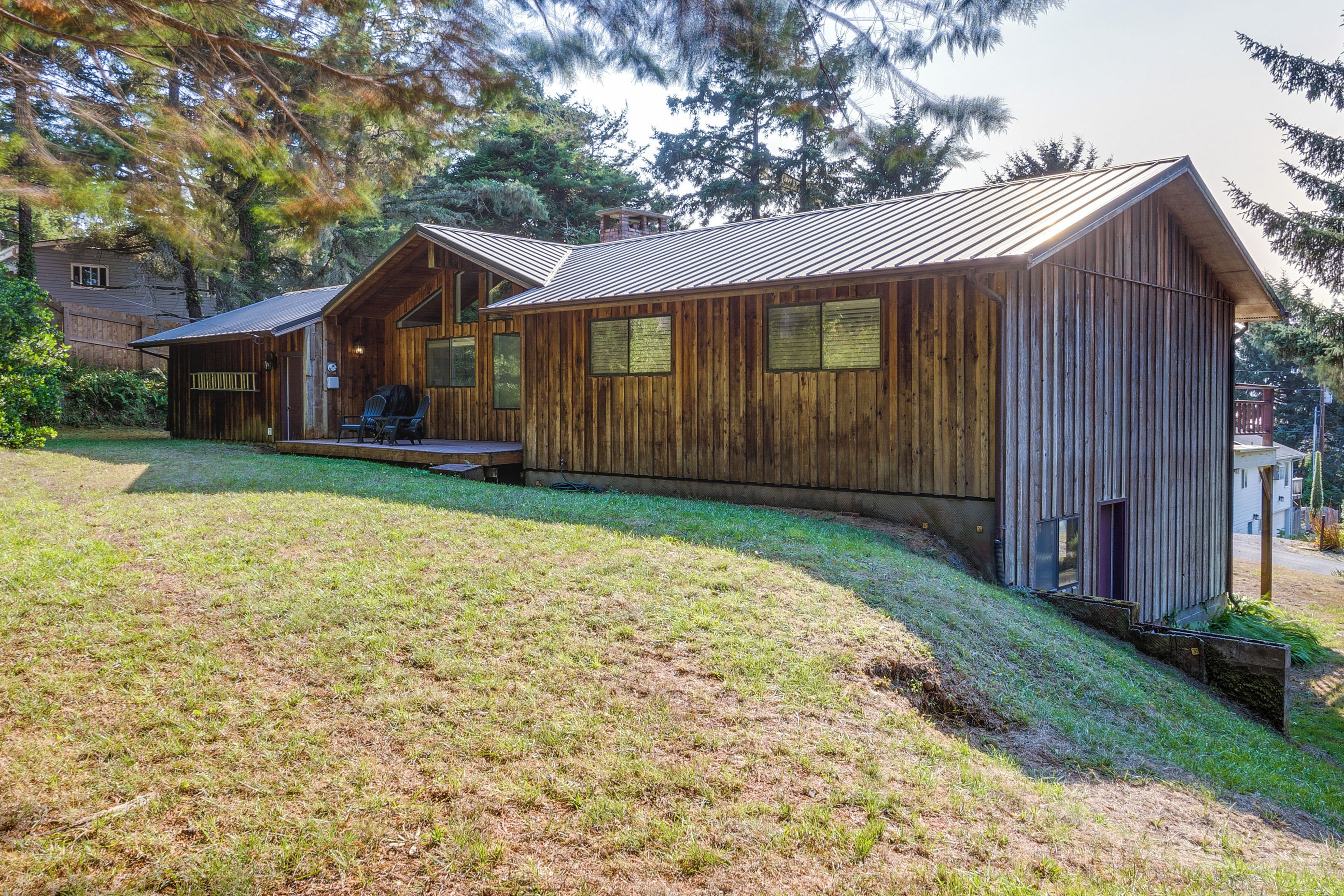A wooden cabin with a sloped roof, a porch, and a small deck.