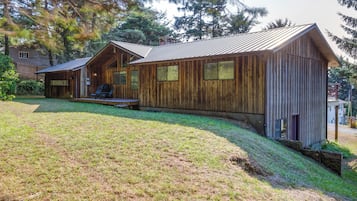 A wooden cabin with a sloped roof, a porch, and a small deck.