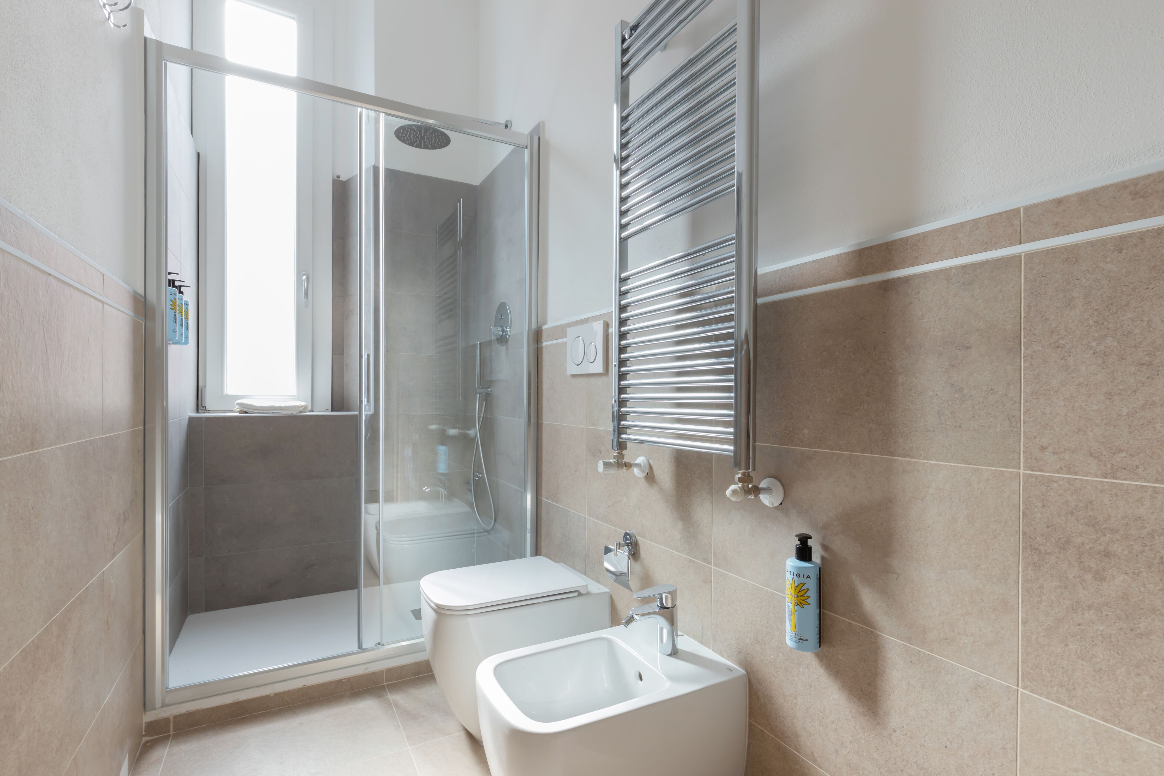 A modern bathroom with a glass shower enclosure, a toilet, and a sink.