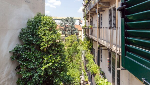 A narrow alleyway between buildings with balconies, some with plants. - Milan Retreats Porta Romana (Milan)