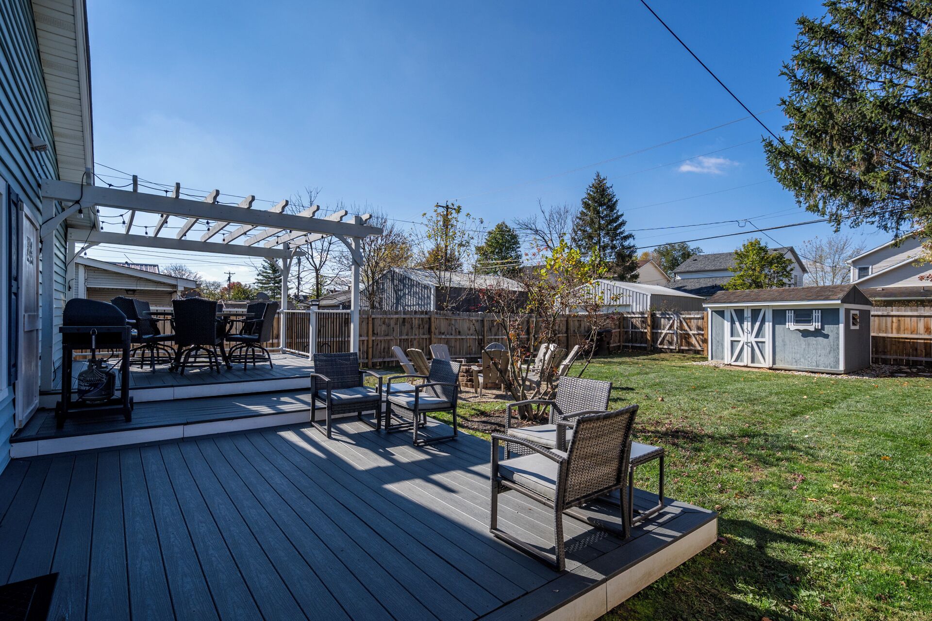 Un patio couvert avec des meubles d’extérieur et un espace barbecue.