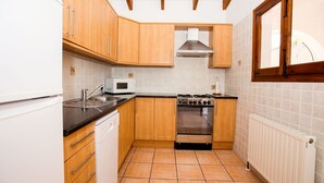 A compact kitchen with wooden cabinets, a built-in oven, a microwave, and a dishwasher. - Villa Cezanne, Sea Views, private pool, breezes, WIFI, close to new ALDI (Moraira-Teulada)